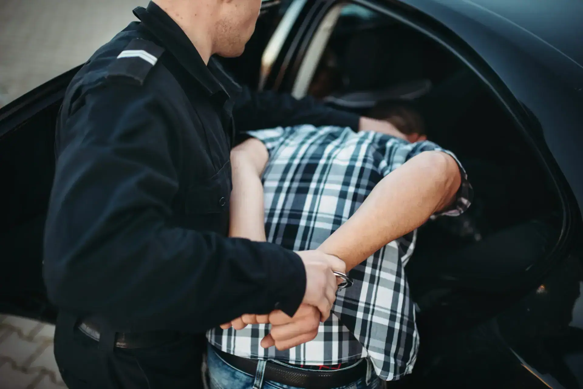 Police officer put the intruder into the car. Cop at the work. Law protection concept, professional safety control