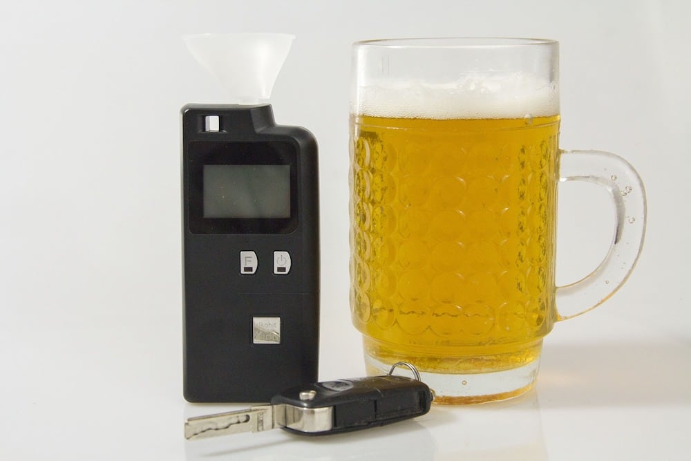 breathalyzer next to a pitcher of beer and car keys