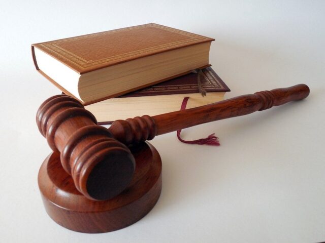 brown gavel on table next to books