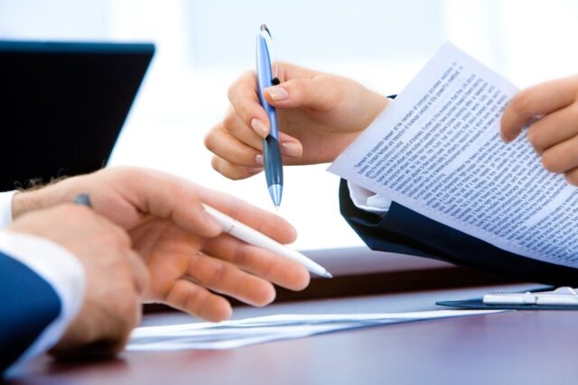 two people signing a legal document