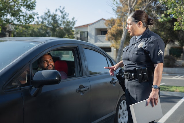 police officer talking to a person driving a car