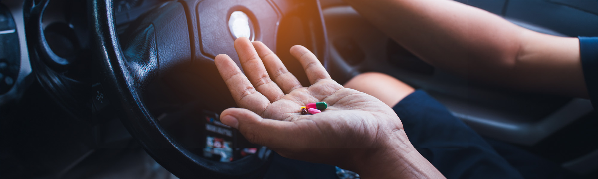 hand of man takes drugs in the car