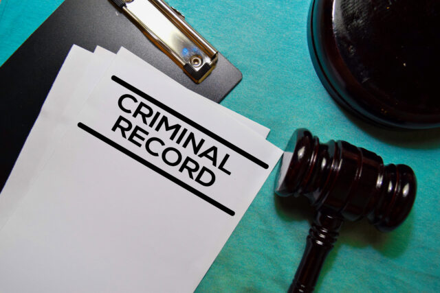 Criminal Record text on Document and gavel isolated on office desk.