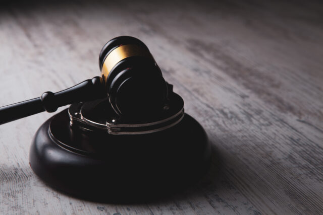 judge's hammer and handcuffs on the table