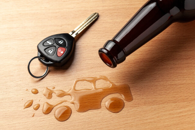 Drunk driving. Accident with a broken car from alcohol. Beer bottle and car keys. Broken car.