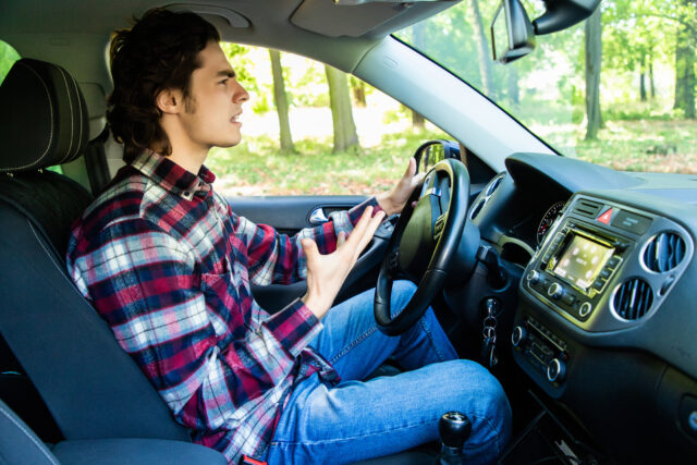 Angry young male driver speeding very fast showing anger as road rage DWI