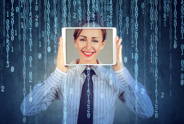 Happy woman holding tablet with her face displayed on a screen isolated on binary code background identity theft